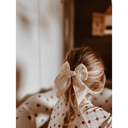 Mašľa do vlasov z organickej bavlny nasadená v blond vlasoch dieťaťa – krémový vzor